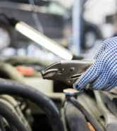 mechanic-man-with-pliers-repairing-car-at-workshop-2024-09-27-13-25-10-utc