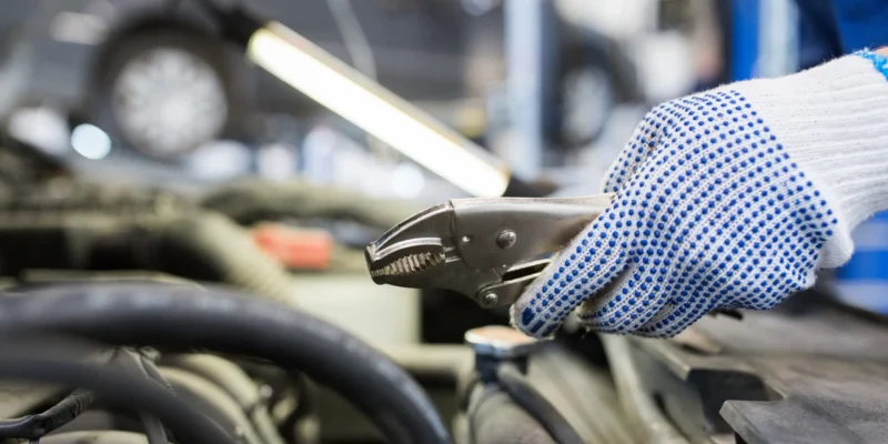 mechanic-man-with-pliers-repairing-car-at-workshop-2024-09-27-13-25-10-utc
